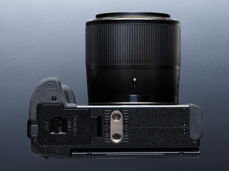 三脚穴はレンズの光軸からずれている。三脚穴の手前に、ビデオカメラでおなじみのVHSピンの穴を備える点はユニークだ。動画機能重視のためだろう