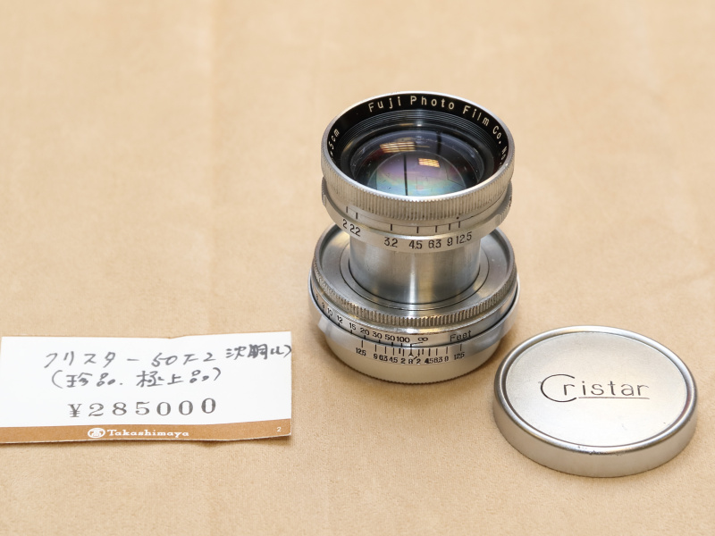 <strong class="">富士写真フイルム／Cristar 5cmF2</strong><br class="">沈胴タイプのLマウントレンズ。製造初年は1949年と言われている。4群6枚のダブルガウスタイプの光学系を採用する。純正のキャップに刻まれたロゴが美しい。（藤井商店）