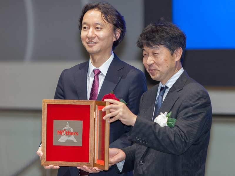 上場通知書を受け取る古俣大介社長（左）