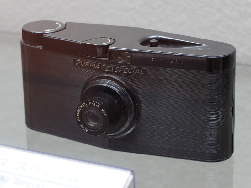 パーマ スペシャル（1937年、ハンター）。127フィルム32×32mm。カメラを縦や横にして構えると3速のシャッタースピードを選べる樹脂製カメラ