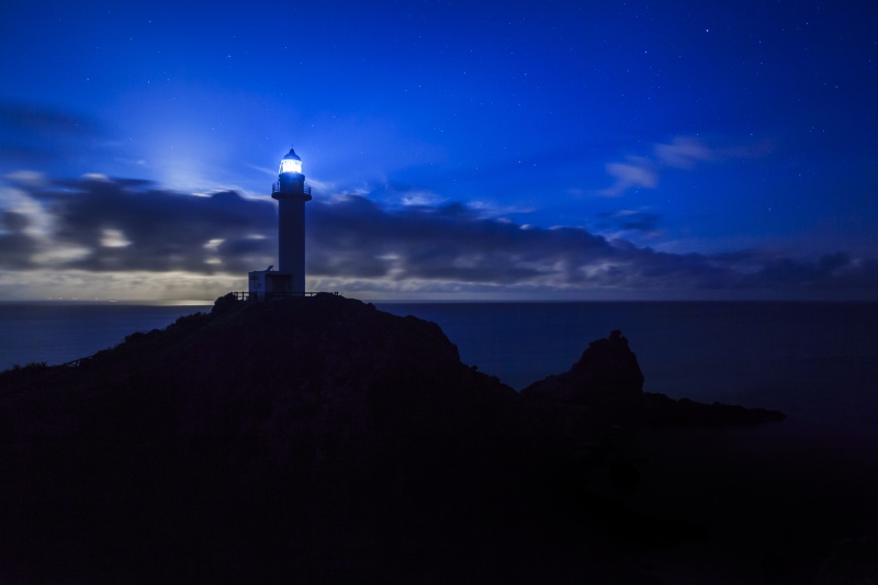 <strong class="">灯台の明かりのみで撮影</strong><br class="">月が雲に隠れている状態で撮影。灯台の明かりのみのため、手前の草むらが真っ暗なままで、灯台にも立体感がない