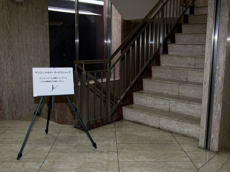 同社のエントランスを入ると、左手にケンコー・トキナーサービスショップへの案内がある