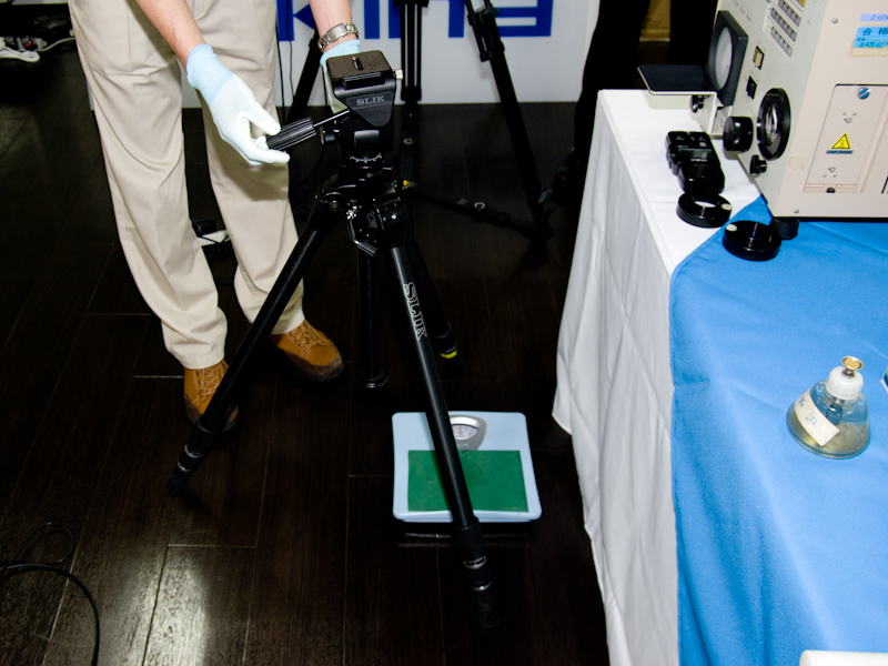 三脚の点検には体重計も使う。力を加えた時、脚がどのくらいの荷重で縮むかを調べる