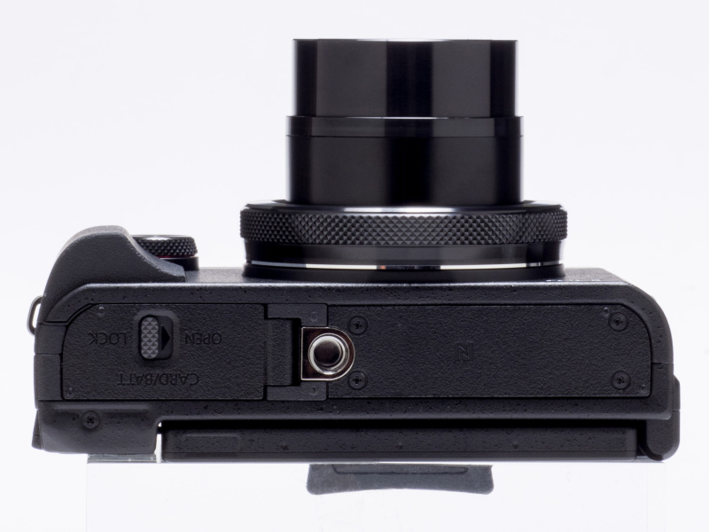 バッテリー/メモリーカード室と三脚穴が配置される。NFC対応機器との接続を行う際には、底面のNFCマークを機器と接触させる