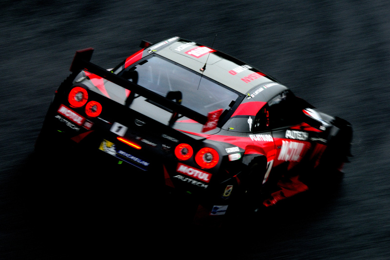 naxtさん「赤い閃光」　雨の中を走る1号車の後ろ姿をヘアピンの入り口側から。車体の赤とテールランプの赤が黒い路面に浮かび上がってとても美しく光っていました