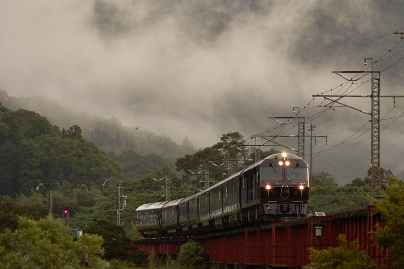 夜明けとともにやって来た「ななつ星in九州」。露光量は不足気味だったが、開放付近の絞り値でもしっかりとした描写力で早朝の空気感まで写しとれた。<br>キヤノン EOS 7D Mark II / EF100-400mm F4.5-5.6L IS II USM / 153mm（245mm相当） / マニュアル露出（F5、1/500秒） / ISO2000