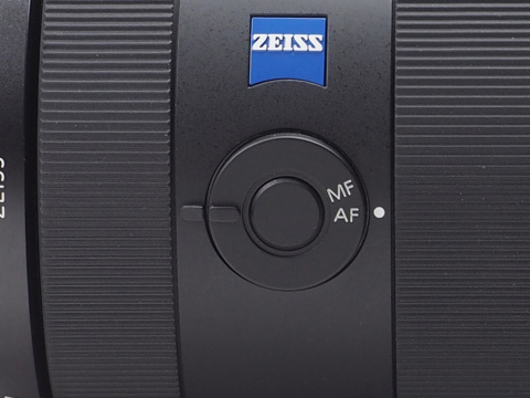 鏡筒側面には円形のフォーカスモードスイッチが配置され、その中心部分にはフォーカスホールドボタンが搭載されている