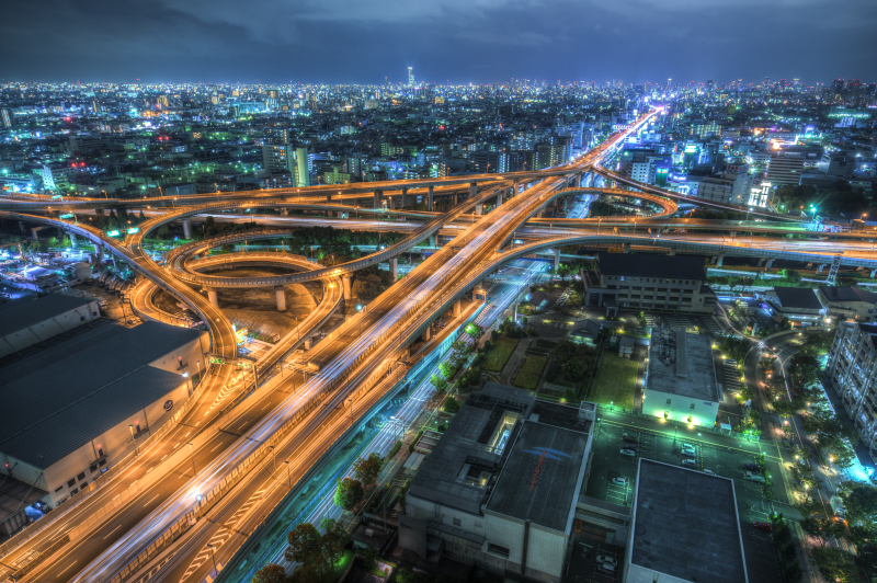 幻想的に浮かび上がらせた、複雑に入り組んだ高速道路のオレンジ色の光。そこにクロスに交差する車の光跡を入れた<br class="">ソニーα7R II／Vario-Tessar T* FE 16-35mm F4 ZA OSS ／22mm／マニュアル露出（F8、10秒）／ISO 800／WB：2,550K