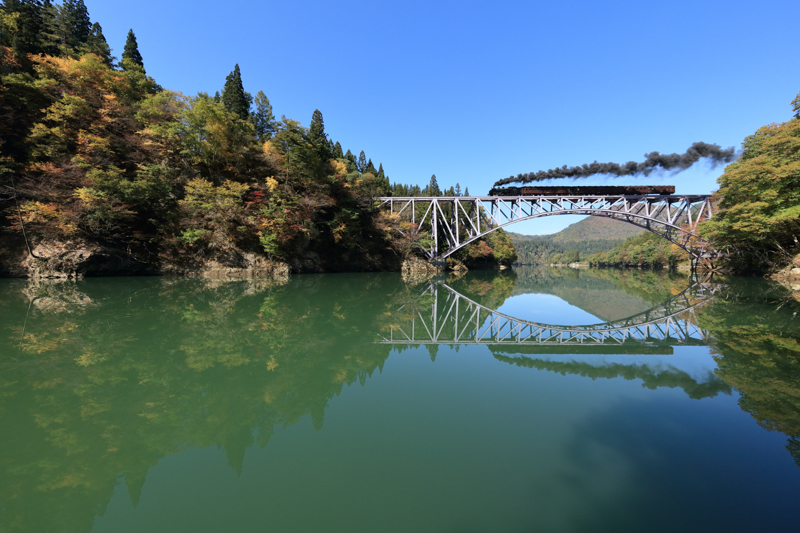 年に一度走るかどうかの只見線SL。この有名なアーチ橋のシンメトリーが撮りたくて、日の出前から撮影ポイントをキープした。鉄橋メインで撮影するのが定番だが、11mmの新鮮な構図を試したかった。<br><span class="fnt-85">キヤノン EOS 5Ds / EF11-24mm F4L USM /13mm / マニュアル露出（F8、0.8秒）/ ISO 640</span>