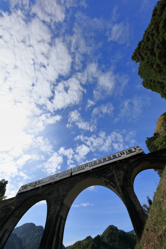 アーチ橋が多い路線である日田彦山線。11mmのパースペクティブを利用して、アーチ橋の迫力を出してみた。レンズはほぼ真上を向いている状態。地元の人に「空を撮っているの?」と声をかけられた。<br><span class="fnt-85">キヤノン EOS 5Ds / EF11-24mm F4L USM / 11mm / マニュアル露出（F10、1/1,600秒） / ISO 800</span>