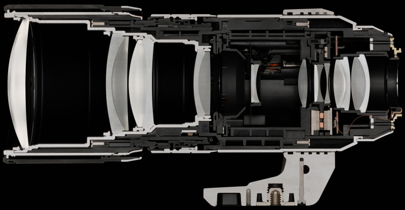 <strong class="">300mm F4.0 IS PROのカットモデル</strong><br class="">断面で白く見えているのがアルミ素材、黒く見えているのがエンジニアリングプラスチック素材だ。小型・軽量化には配慮しつつ、600mm相当のPROレンズとしての精度と堅牢性を保つために必要な個所には、肉厚のアルミ素材をしっかり採用している