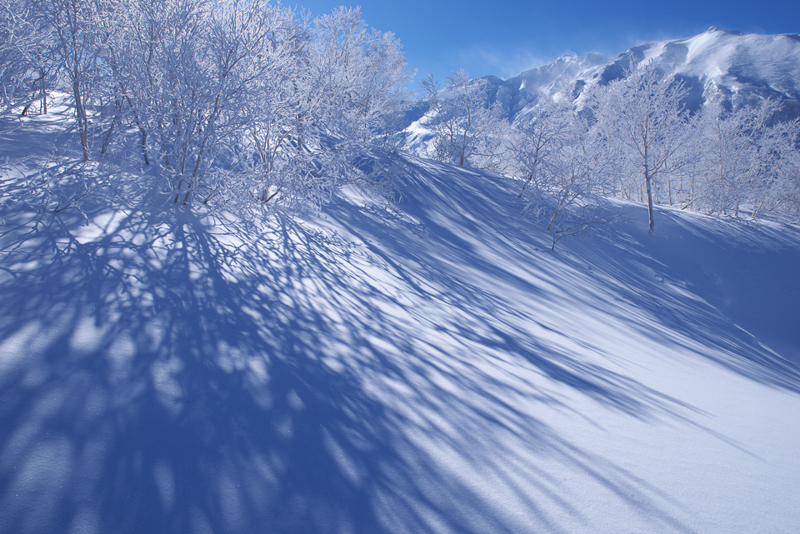 山岳エリアに向かうと、空や影の青さが変わる。丘で見ている青とは次元の違う色彩に、いつも感動しながら撮影している。厳しい気象条件が作り出す雪の模様や木々を覆う霧氷など、別世界を堪能できるのが山岳エリアの特徴だ。<br class=""><span class="fnt-85">PENTAX K-1 / HD PENTAX-D FA 24-70mmF2.8ED SDM WR / 2秒 / F2.8 / ISO 400 / 50mm</span>