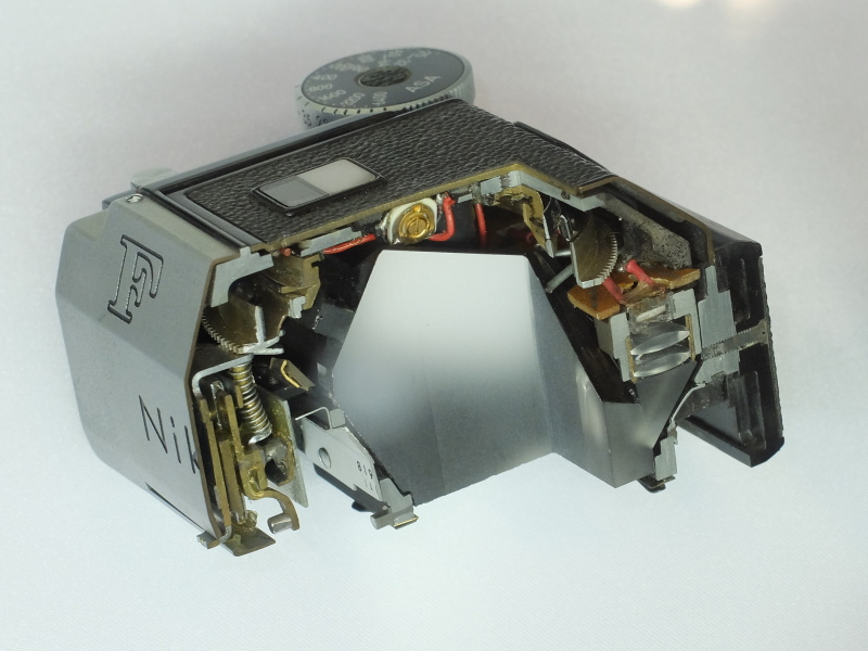 ニコンF用フォトミックファインダーのカットモデル。電子的な測光メカニズムと、カニのはさみに連動する前面の機械的な見どころが共存する