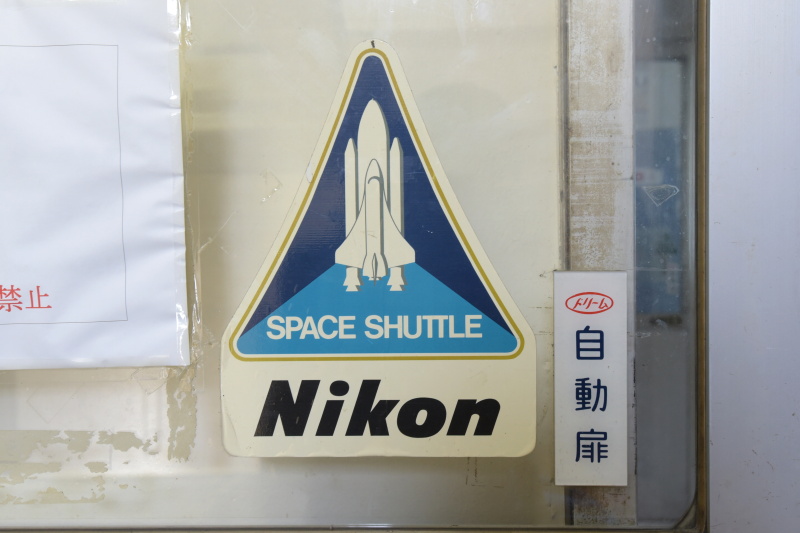 扉に、スペースニコンと思しきステッカー。グッズ化してほしい