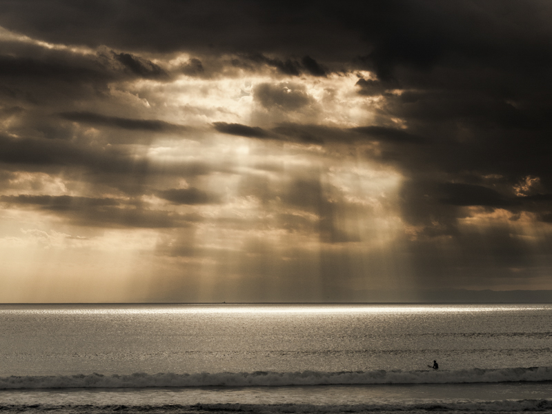 平日の午後ということもあって珍しく空いている鵠沼の海。雲間から差し込んだ光が水面を照らしていた。波待ちのサーファーもその美しさに見とれている様子。柔らかな光の筋と雲の立体感をよく描写している。<br class=""><span class="fnt-85">オリンパス OM-D E-M1 / M.ZUIKO DIGITAL 45mm F1.8 / 45mm（90mm相当） / 絞り優先AE（F6.3、1/1,250秒、-0.3EV） / ISO 200</span>