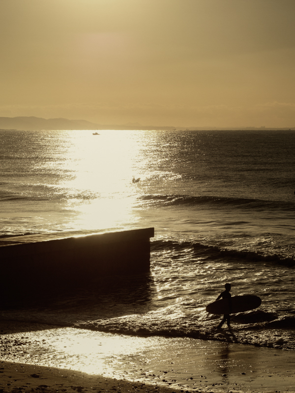 早朝、茅ヶ崎の海に入ってゆくサーファー。日の出のタイミングという強烈な逆光の中、写真が破綻してしまうのではないかと不安になったが、1/8,000秒の高速シャッターとZEROコーティングのお陰でしっかりと写し取ることができた。<br class=""><span class="fnt-85">オリンパス OM-D E-M1 / M.ZUIKO DIGITAL 45mm F1.8 / 45mm（90mm相当） / 絞り優先AE（F5.6、1/8,000秒、-0.3EV） / ISO 160</span>