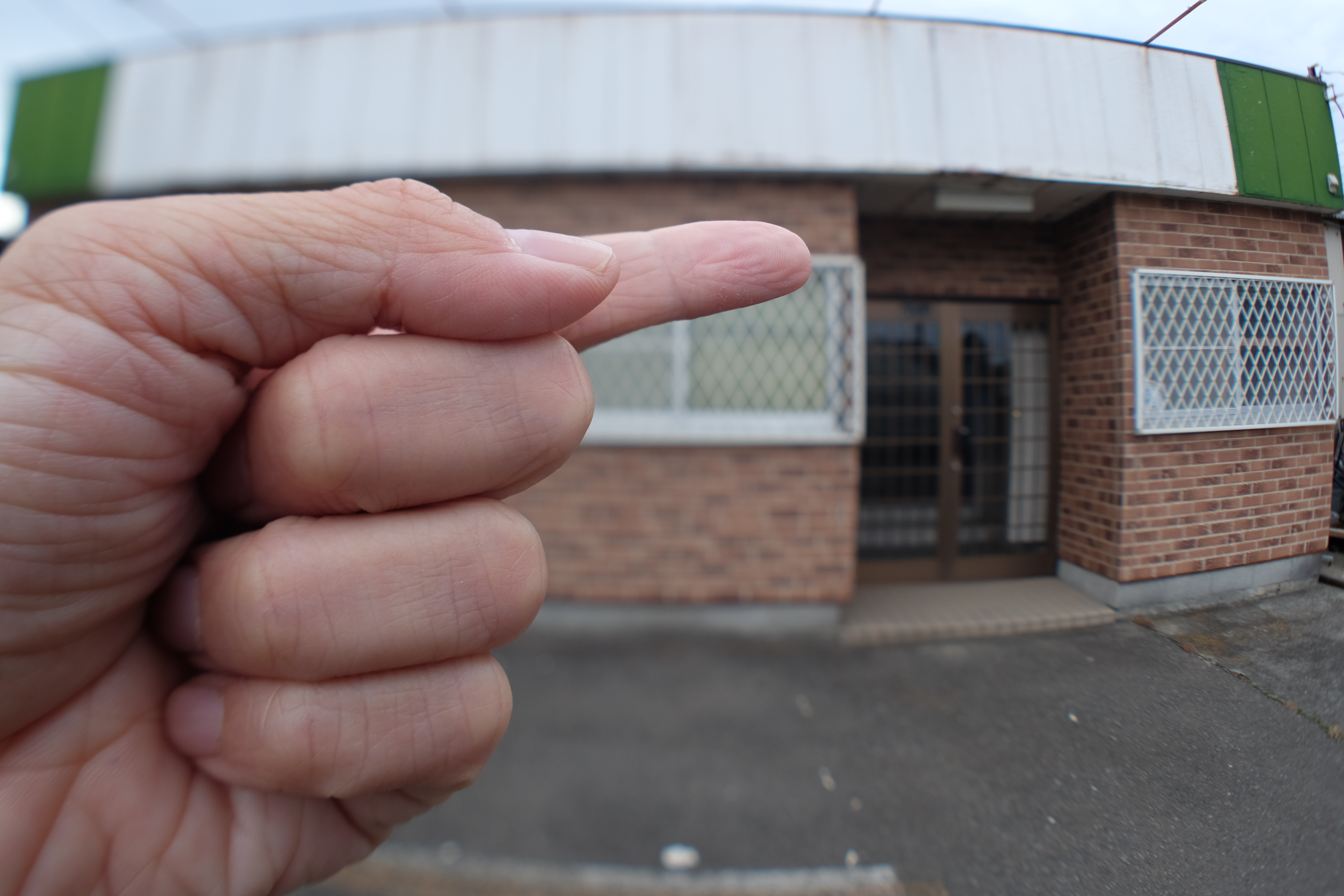 ピントリングを調整して、画面右端は遠景の建物にピントが合うようにした。するとティルトの効果によって、画面左の手前にかざした手にピントが合う。こういう撮影システムを、今回は作ってみたのである。