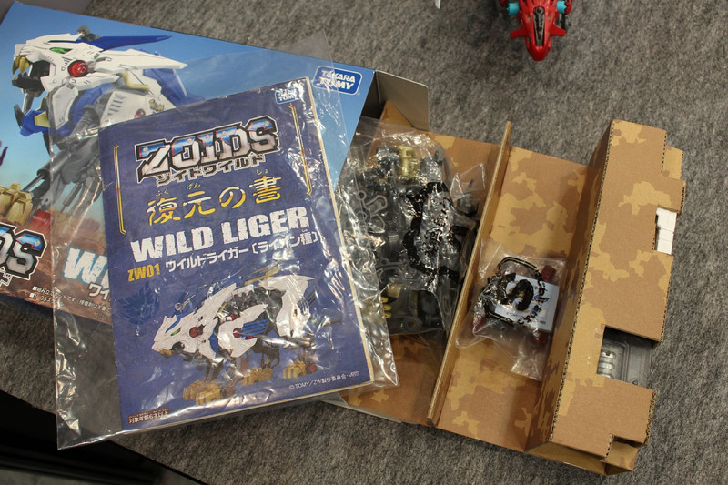 製品と同等のパッケージのサンプル。パック分けされたパーツと動力のメカユニット、そして説明書「復元の書」が封入