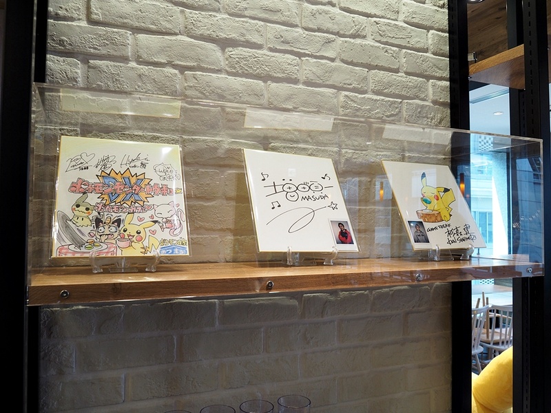 カフェのあちこちに大小様々なぬいぐるみや関連グッズなどが置かれ、漫画作品やゲーム製作に携わったスタッフのサインも展示されている