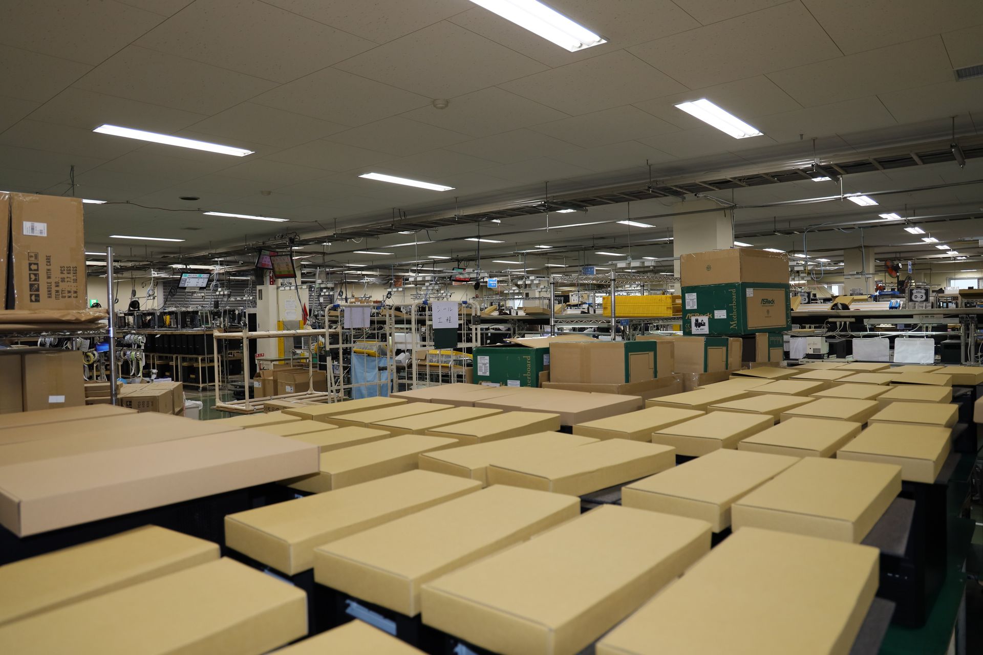 ケースとキットボックスのシマの奥に広大な製造エリアが広がっている