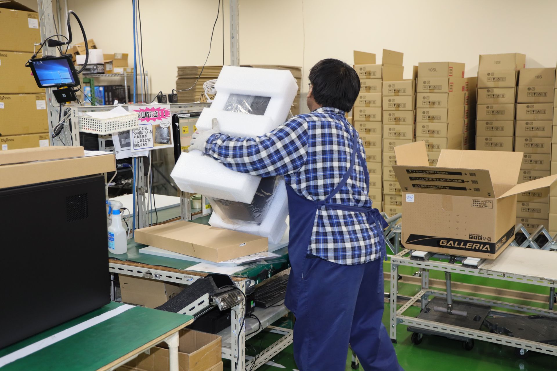 PCにビニールと緩衝材を手慣れた手つきで被せていく