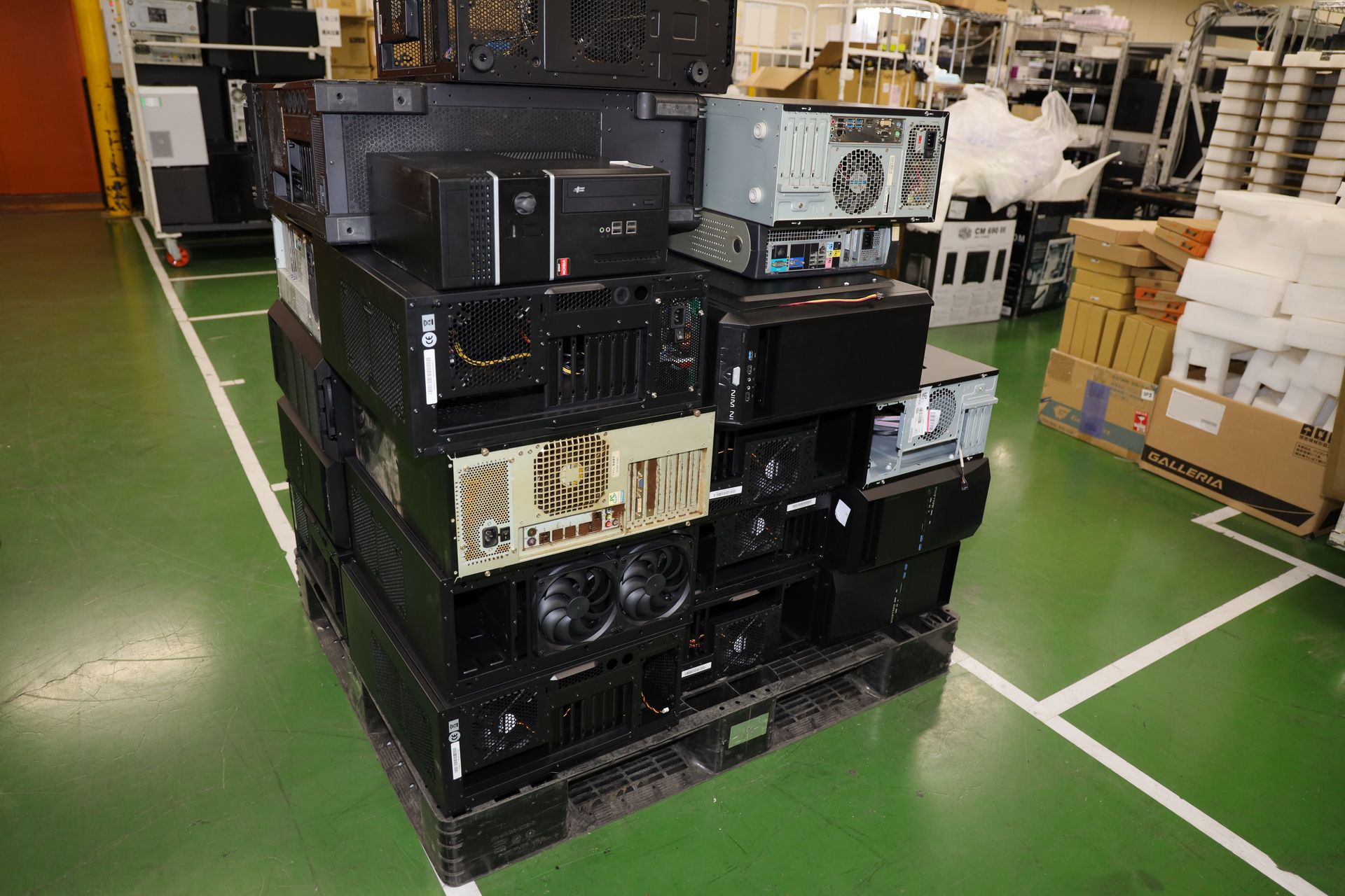 山と積まれた下取りPC。3段目に積まれているPCのファンには埃がギッシリ詰まっている