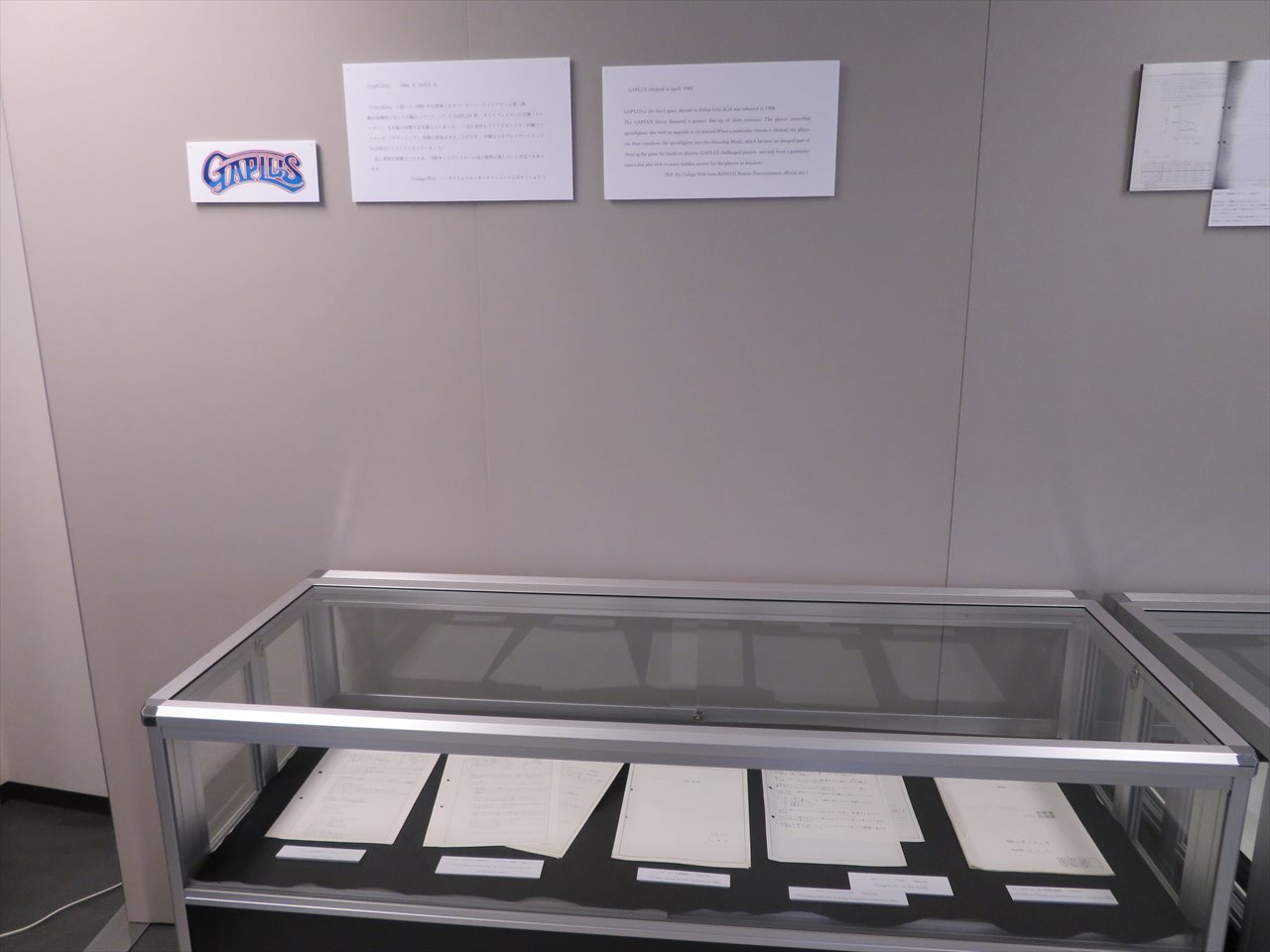 壁面にびっしりと並べられた「ギャラクシアン」、「ギャラガ」、「ギャプラス」の開発資料。壁面のものはコピーだが、ショーケース内には本物の資料も展示されている