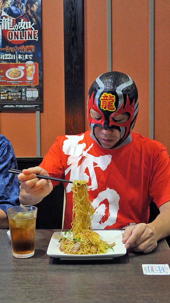 「男の肉塩焼そば」をほおばるドラゴンマスク1号氏。すぐに完食していた
