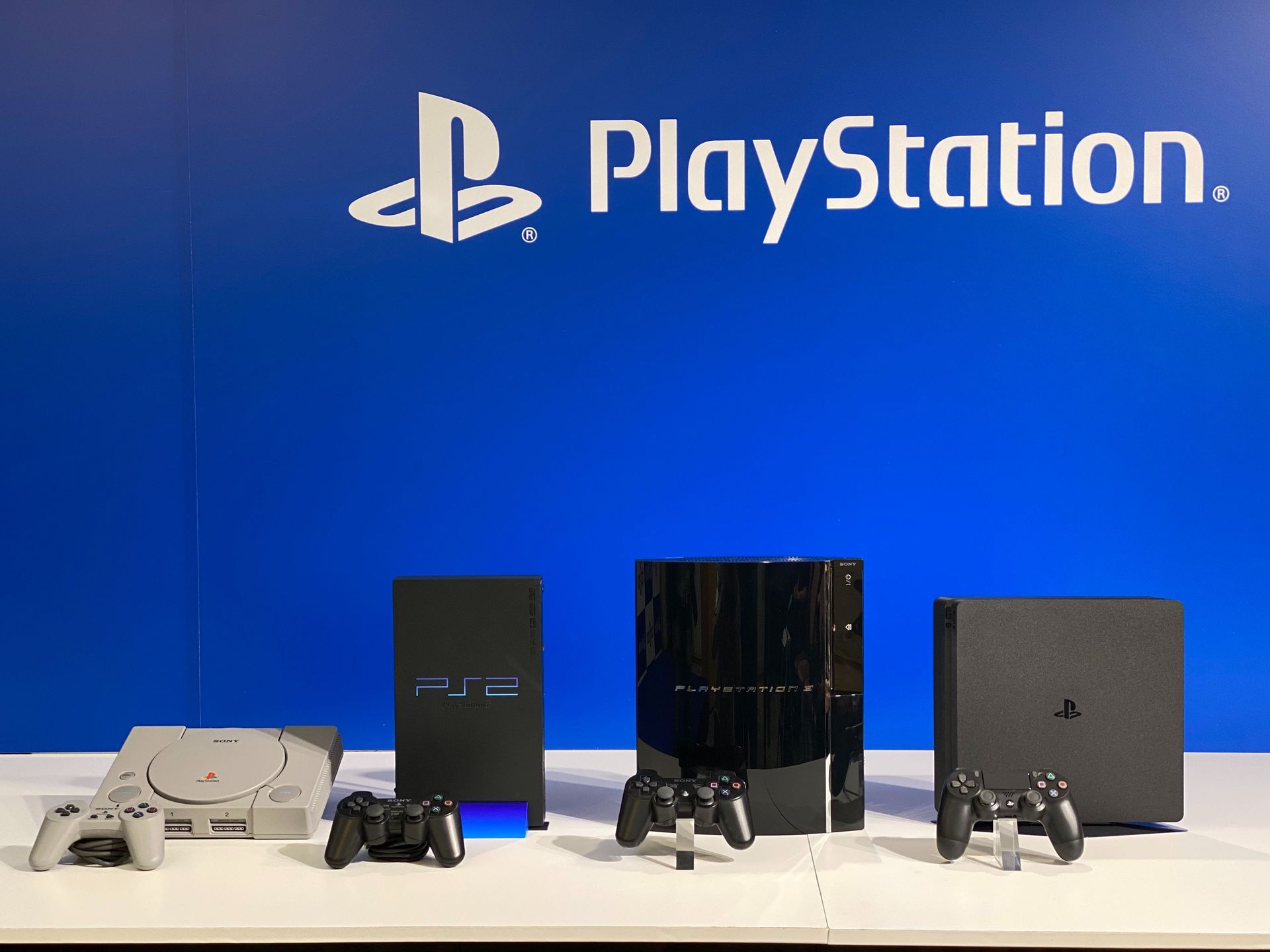 左から順にプレイステーション（1994年12月発売）、プレイステーション 2（2000年3月発売）、プレイステーション 3（2006年11月発売）、プレイステーション 4（2013年11月発売）