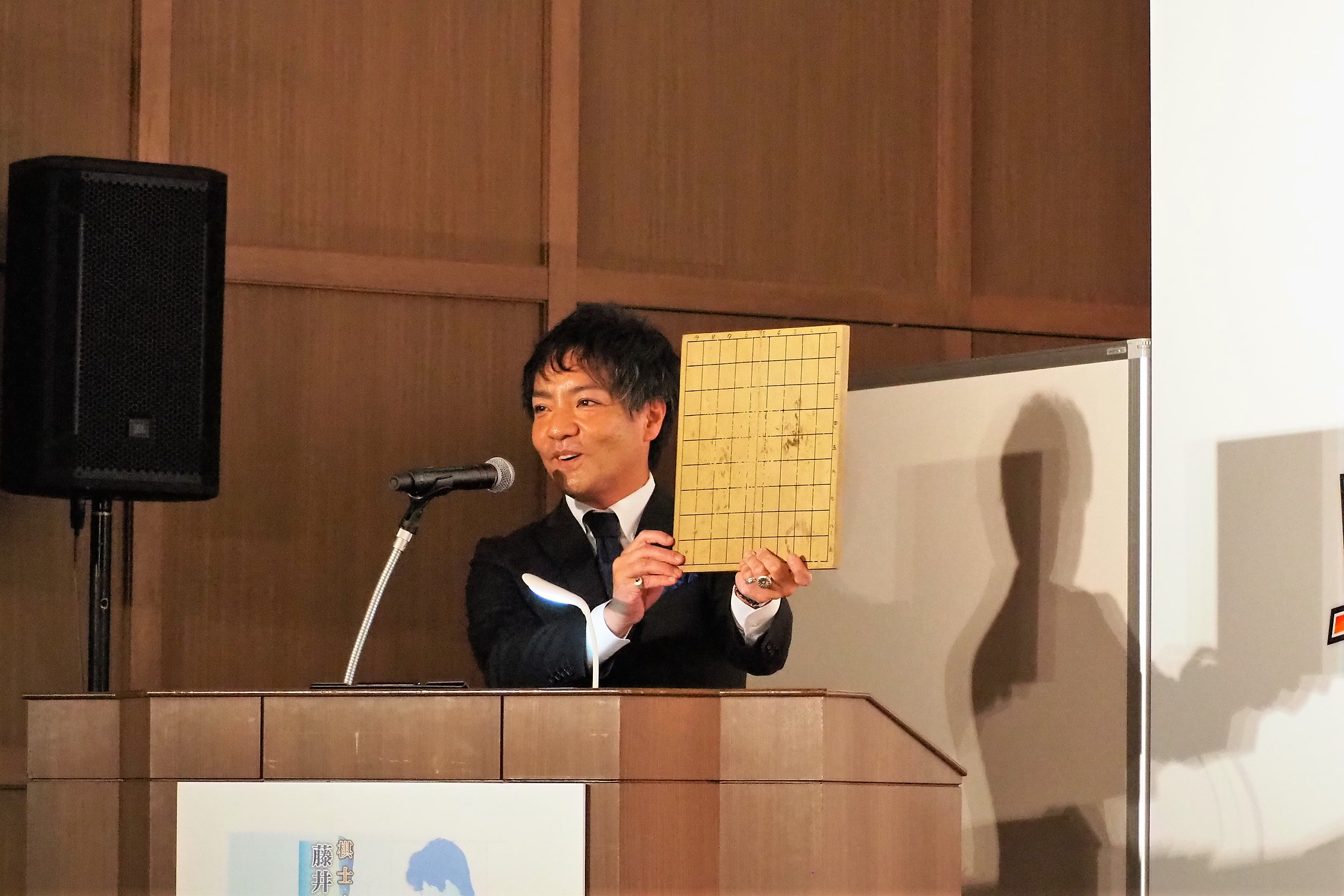 司会の方が掲げている将棋盤は、昭和38年に任天堂が販売していたものだ