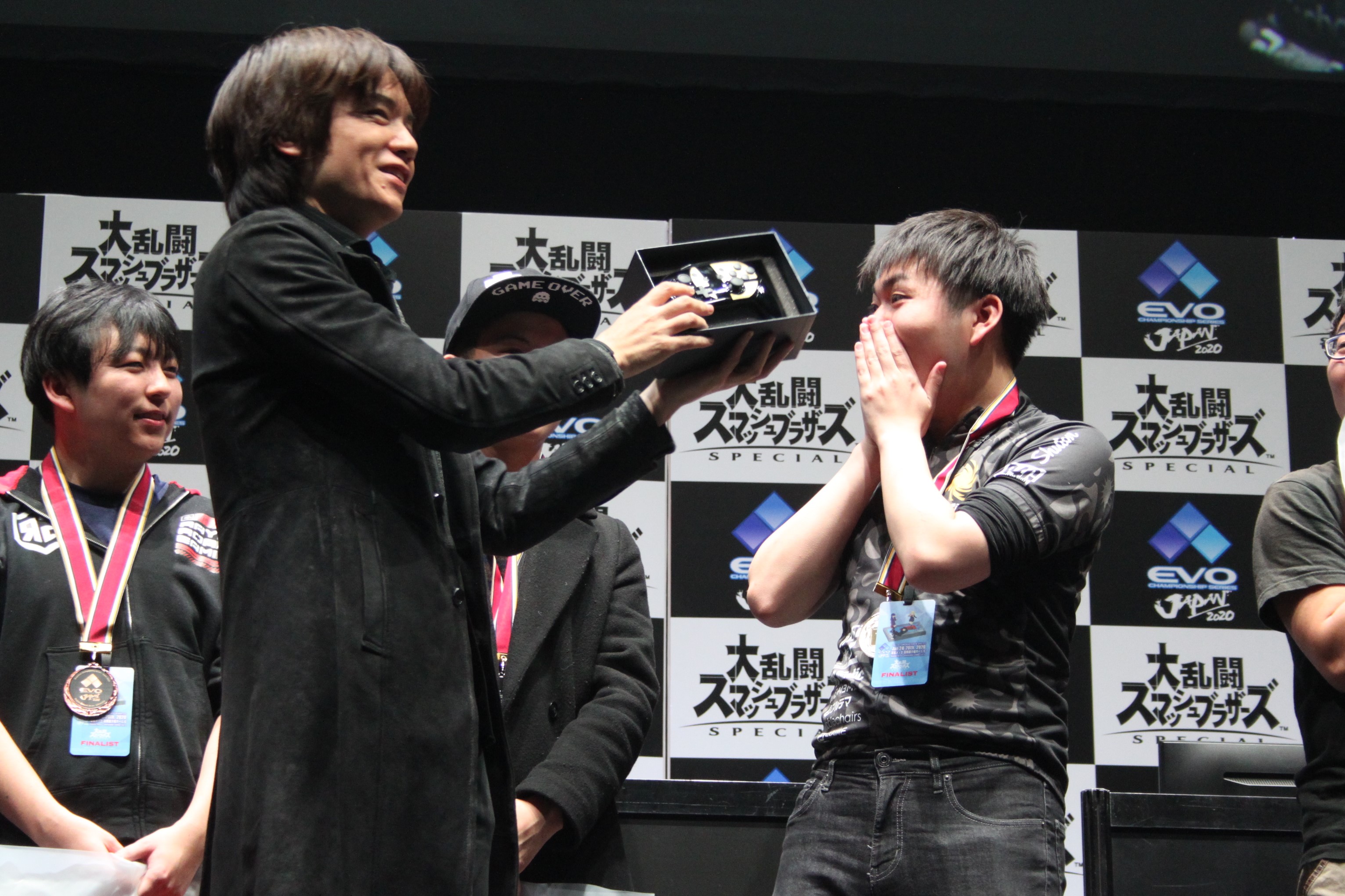 桜井氏からコントローラーを受け取るShuton選手