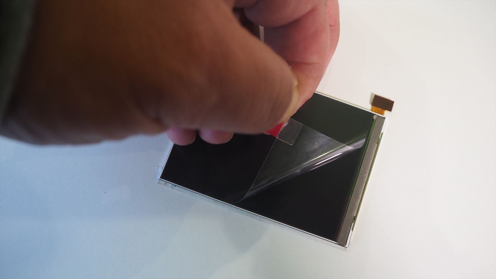 ピンクの部分をつまんで、保護シートを剥がす