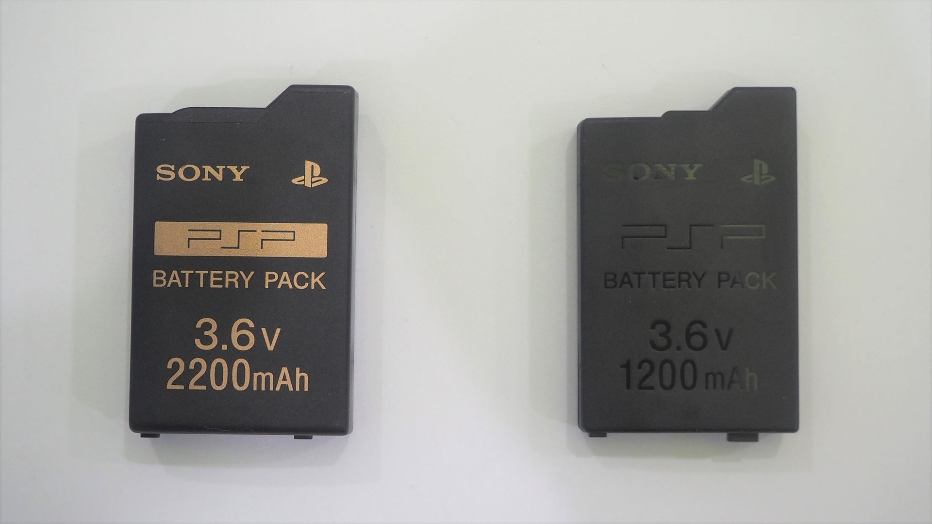 なお、初代PSP（PSP-1000）とPSP-2000/3000ではバッテリーの形状が異なり、互換性がないので要注意。左がPSP-1000用純正バッテリーで、右がPSP-2000/3000用純正バッテリーである