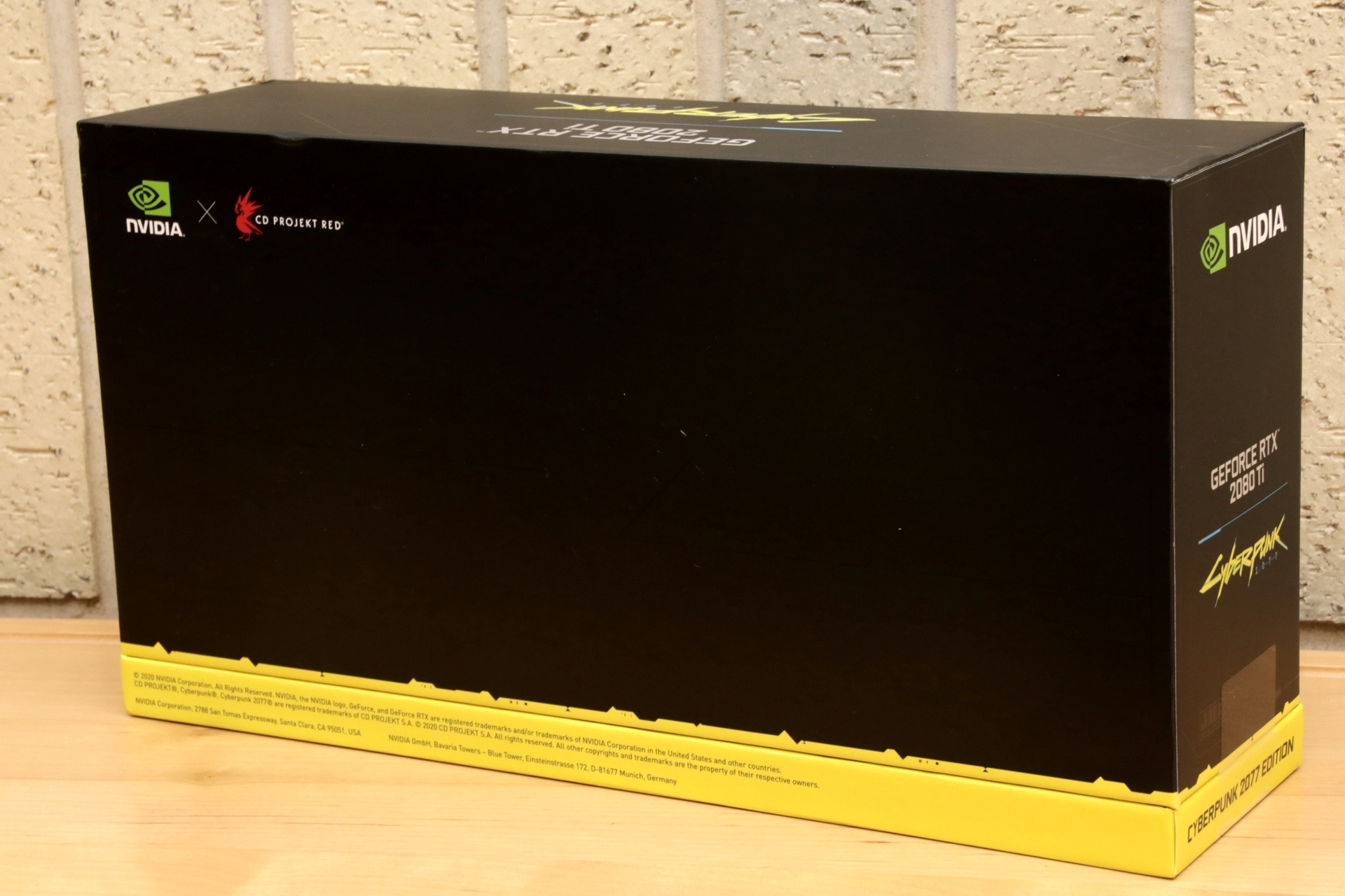 表面にはロゴと主人公「V（男性）」の姿が描かれ、「GeForce RTX 2080 Ti」と「Cyberpunk 2077」のダブルネームが側面と天面に記されています。カッコええ……。プレゼント品は未開封となりますので、中身は上記動画にてご確認ください