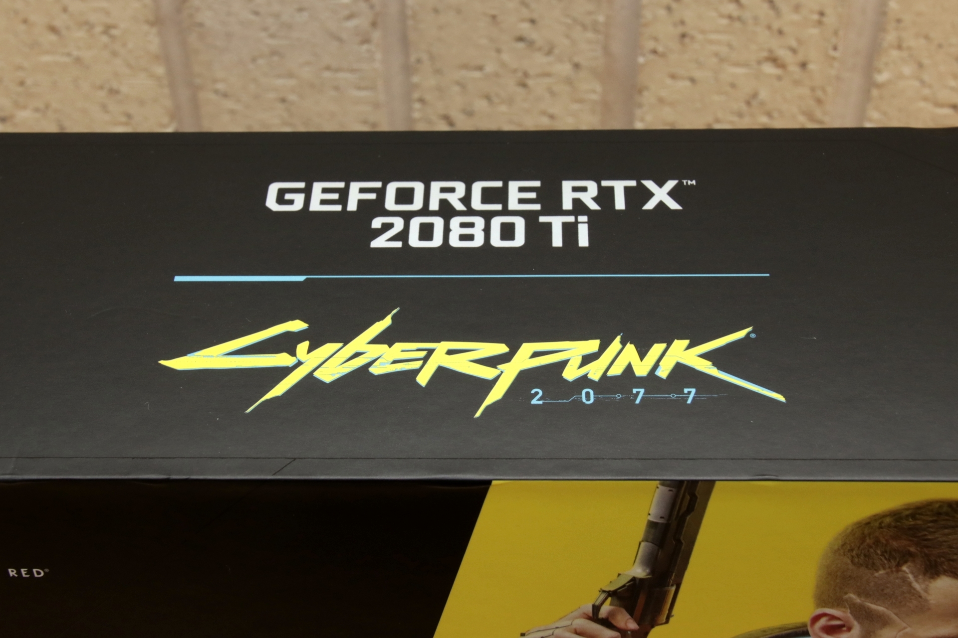 表面にはロゴと主人公「V（男性）」の姿が描かれ、「GeForce RTX 2080 Ti」と「Cyberpunk 2077」のダブルネームが側面と天面に記されています。カッコええ……。プレゼント品は未開封となりますので、中身は上記動画にてご確認ください