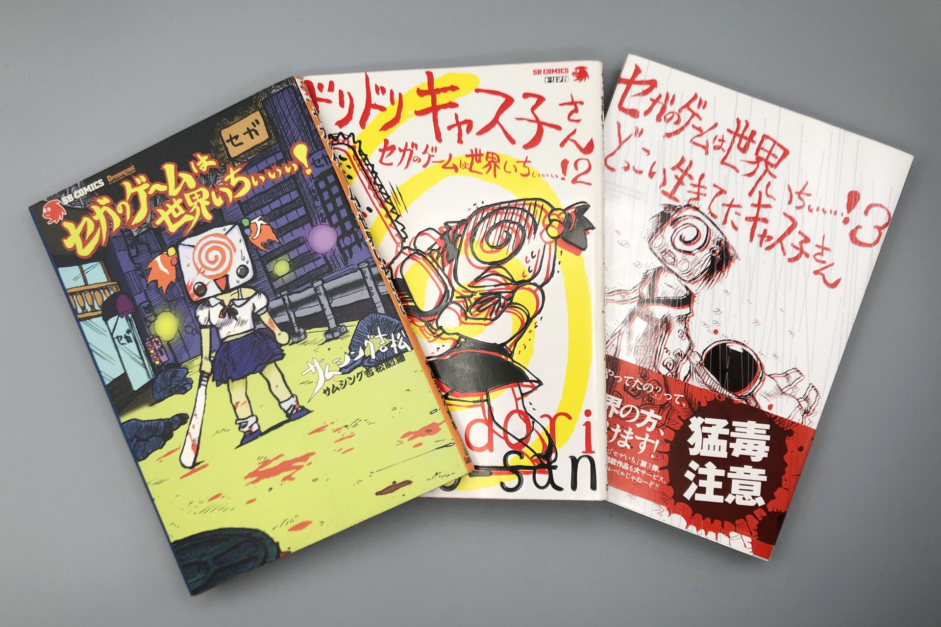 【作品紹介】アスキー「TECH SATURN」の連載コミック「メガドラ兄さん」を経て1997年9月の同誌の休刊により「セガサターンマガジン」へと移籍し、「コミックサタマガ」の枠で「セガのゲームは世界いちぃぃぃ！」のタイトルで'97年12月12日号より連載開始。メガドラ兄さん（メガドライブ）、キャス子（ドリームキャスト）、サタ郎（セガサターン）、ギア夫（ゲームギア）、ナオミ（NAOMI）など、セガハードを擬人化したキャラクターを中心に、ゲーム業界のリアルタイムな話題を自虐的に描く。連載は「ドリームキャストマガジン」から「ドリマガ」まで続き、その終了後も「週刊プレイボーイ」や「CONTINUE」などで復活する。単行本は3巻が発売