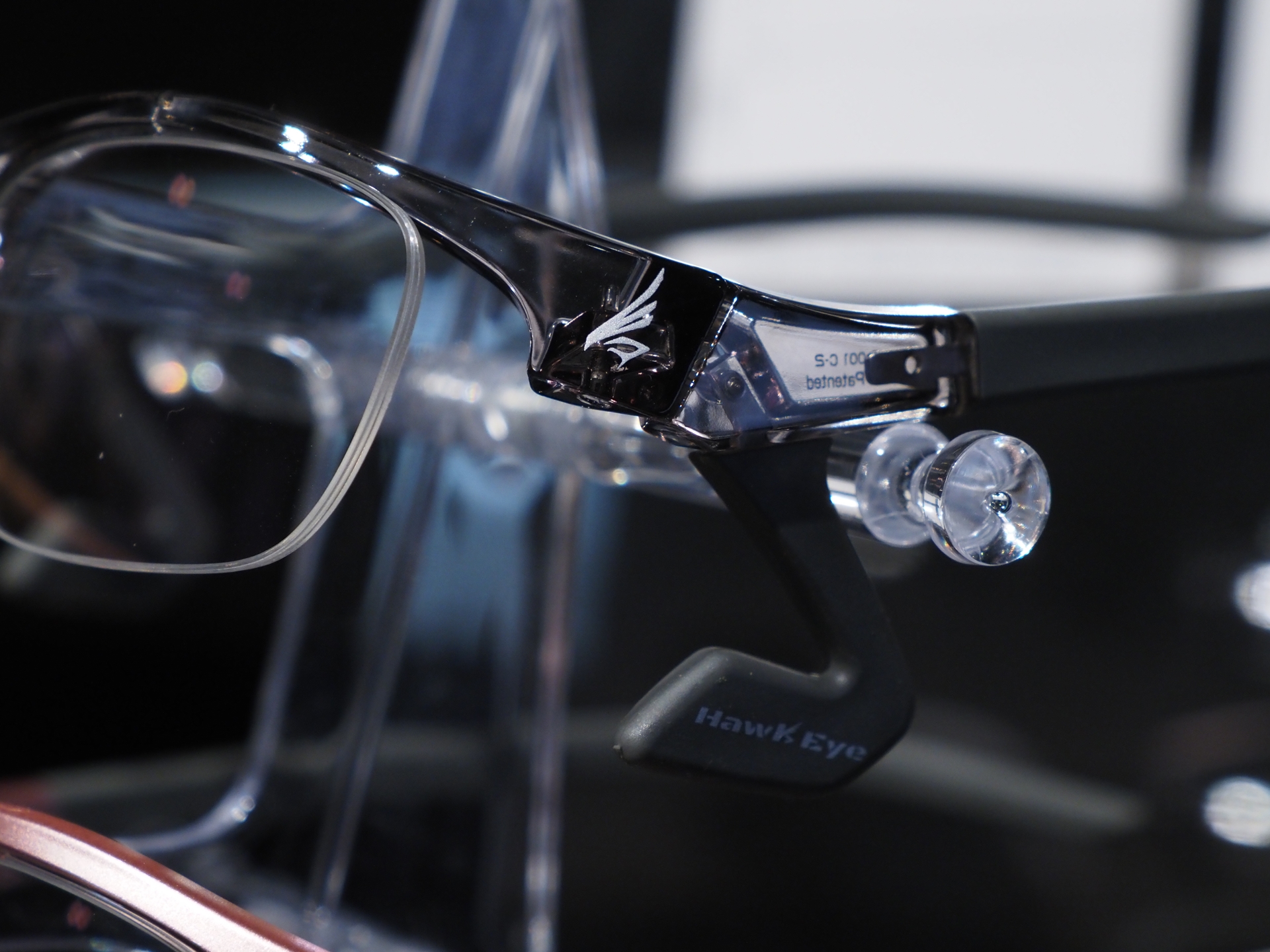 「HawkEye」のカラーバリエーションはマットブラック、スケルトングレー、ピンクグレーの3色。ツムジに向けて側頭部に回り込む長めのツルと、蝶番近くにあるL字型の頬パッドでフレームを支える「クアッドリフトフレーム」方式を採用している