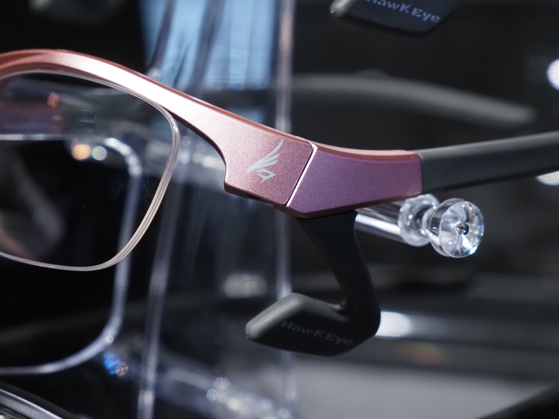 「HawkEye」のカラーバリエーションはマットブラック、スケルトングレー、ピンクグレーの3色。ツムジに向けて側頭部に回り込む長めのツルと、蝶番近くにあるL字型の頬パッドでフレームを支える「クアッドリフトフレーム」方式を採用している