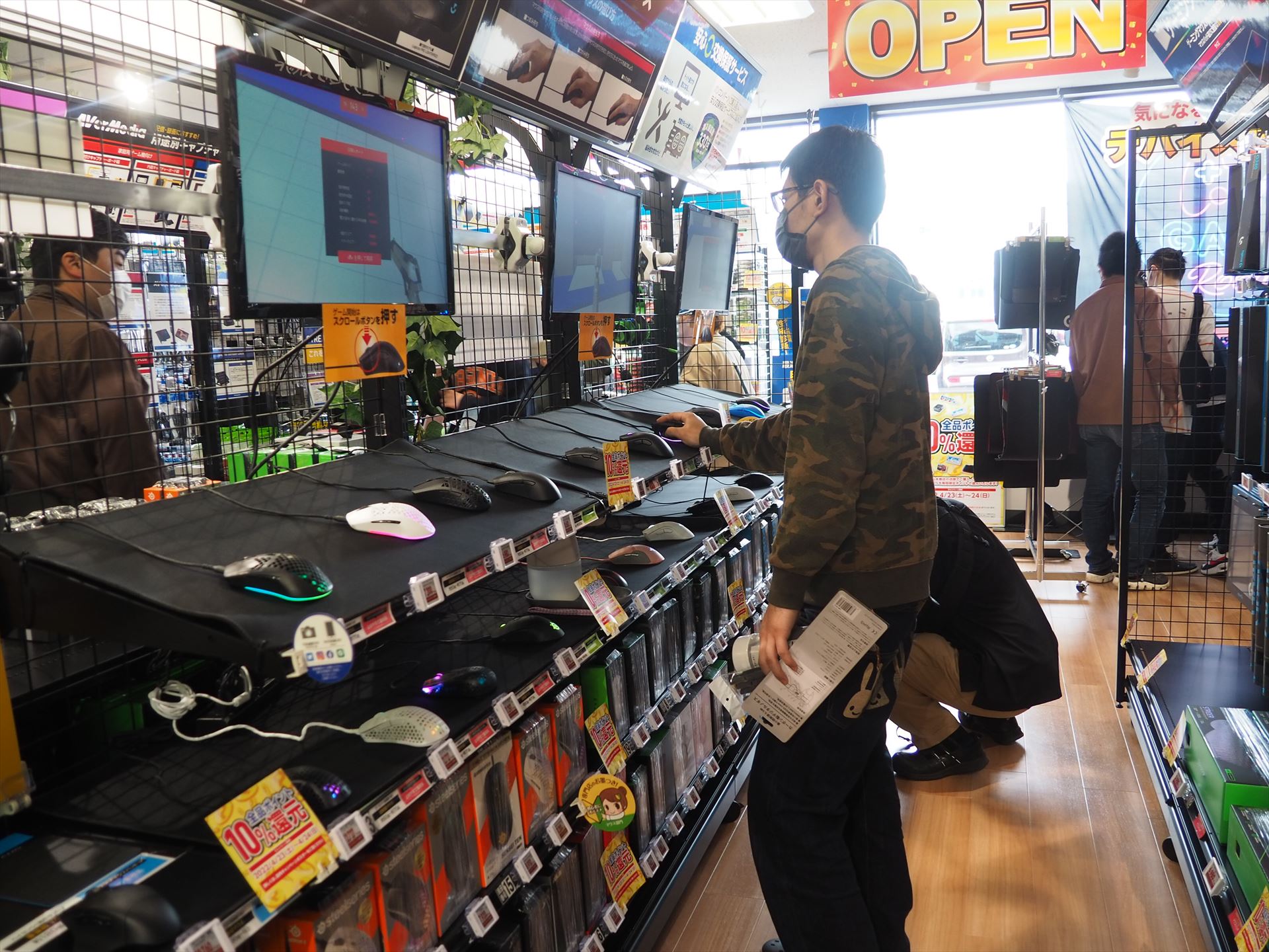 ゲーミングマウスコーナーでマウスの操作感を試している客