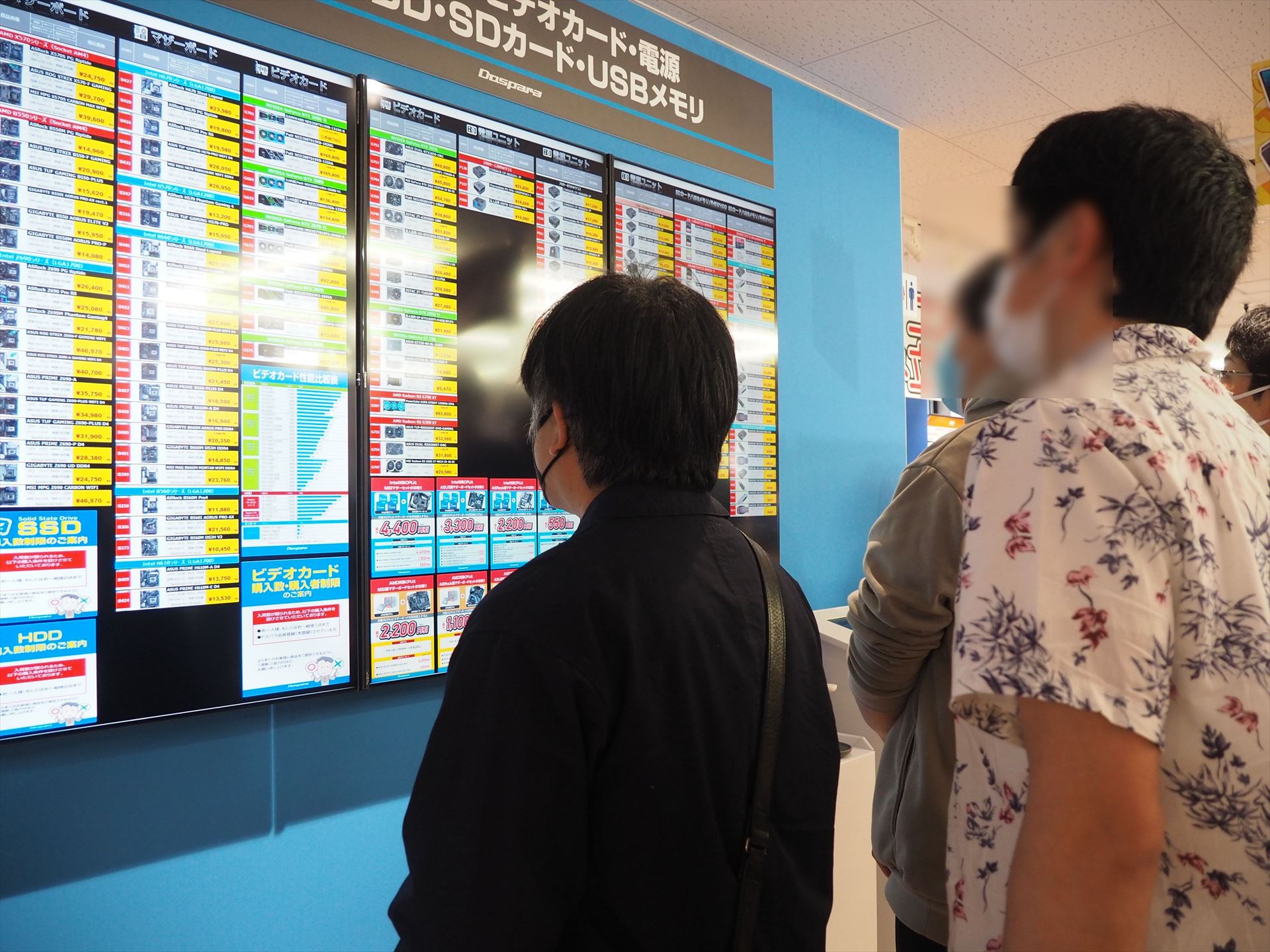 マザーボードやビデオカード、電源ユニットなどの在庫と価格が表示されている大型サイネージにも客が集まっていた