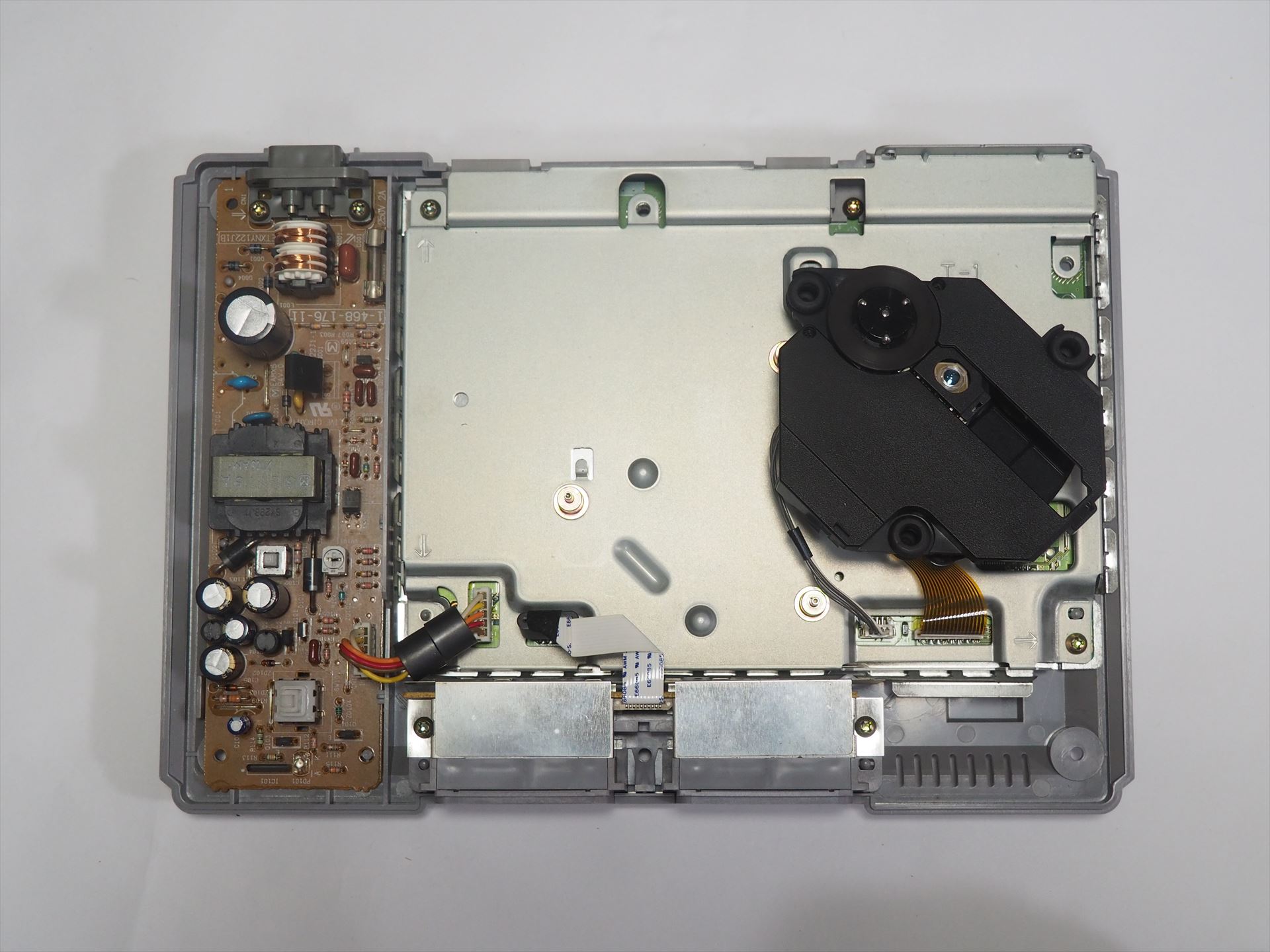 黒いのはCD-ROMドライブユニット。左側は電源回路だ。見えているネジを全て外せばよい