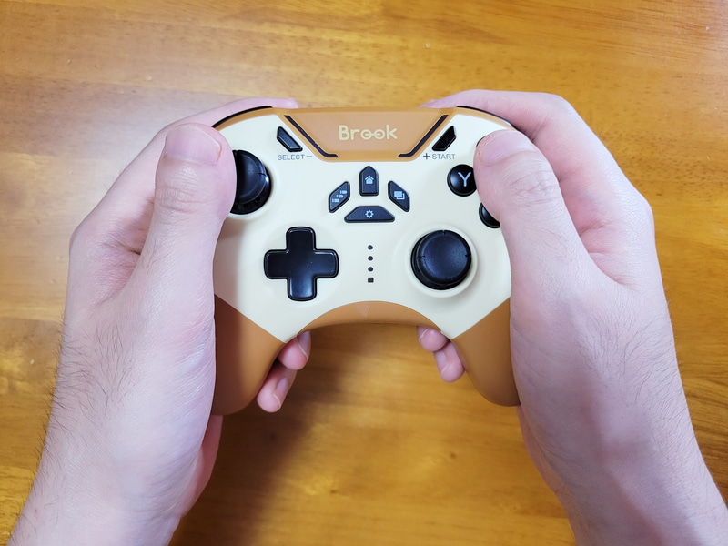 実際に握ってみるとこのような感じですっぽりと手に収まる位のサイズ感だ。各ボタンへは指を伸ばせば余裕でアクセスできる。背面ボタンへのアクセスもコントローラーを握ったまま可能。さらに少し指を伸ばせばポジションを崩さずにモード切り替えもできるため、忙しめのアクションゲームでも問題なく各機能を発揮できそうだ