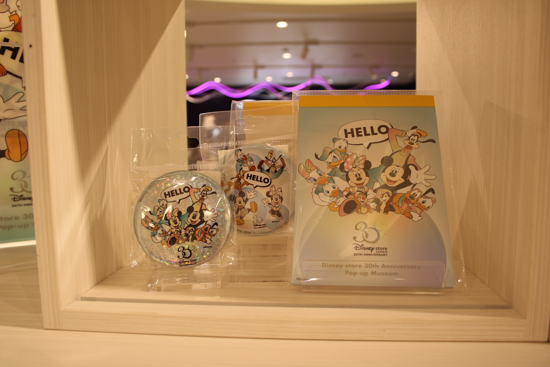 「缶バッチ」275円（税込）。「ポストカードセット」330円（税込）