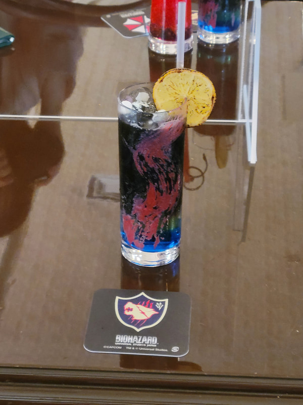 独特のマーブルカラーのドリンクが「リッカー ～t-ウィルスの突然変異～」で、鮮やかな赤色のドリンクが「ハウンドウルフ ～クリス・レッドフィールドが率いる精鋭部隊～」だ。クリスイメージのドリンクはともかくクリーチャーをイメージしたドリンクと言うのは中々に攻めた内容だが味はしっかりと甘味を感じる内容となっている。どちらも注文するとそれぞれのシンボルが描かれたコースターをゲットできる！