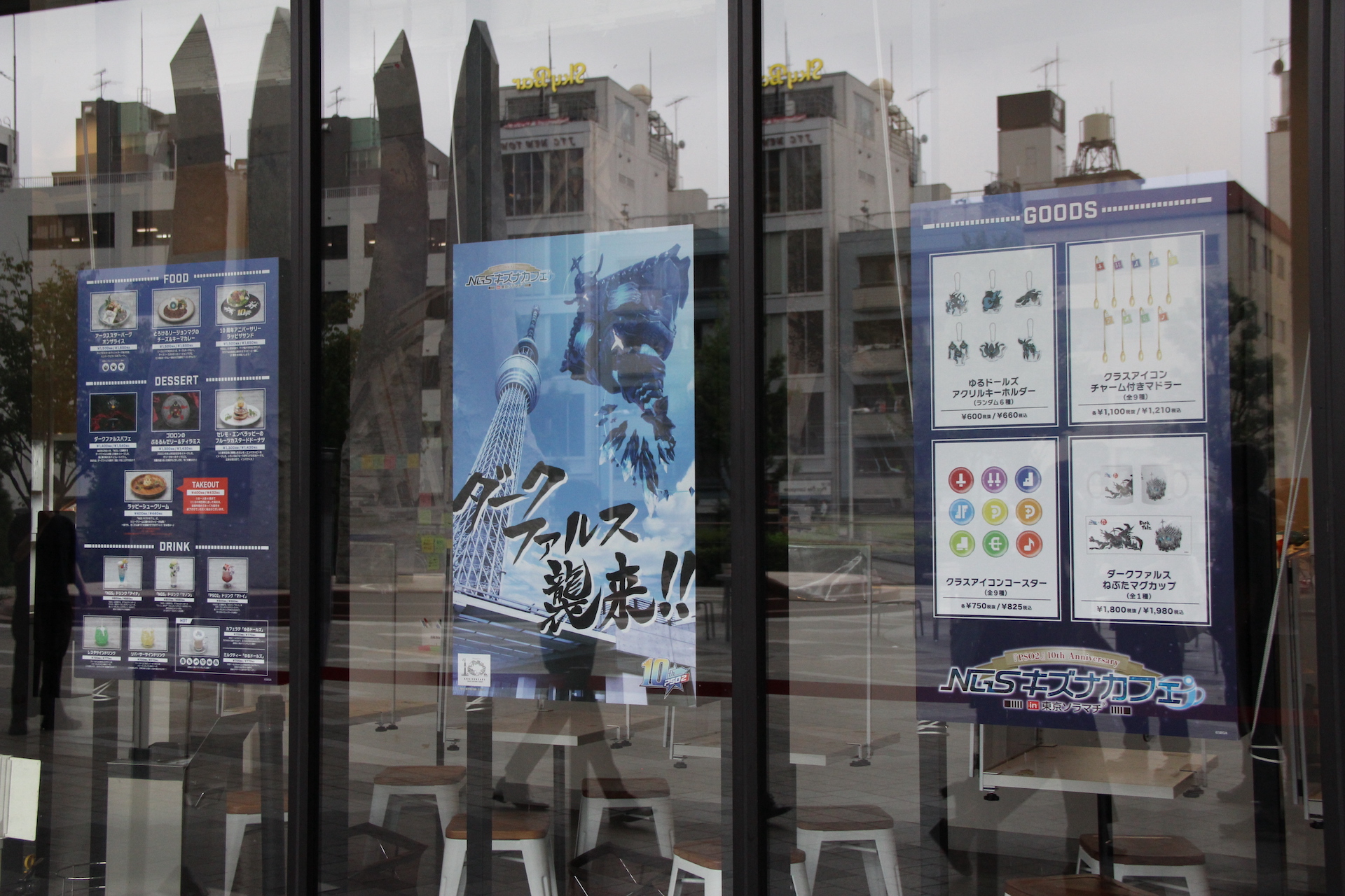 入り口の看板には、「NGSキズナカフェ」と大きく描かれているのが目立つ。窓には商品案内ポスターが張ってあるほか、ヒロインタペストリーも飾られている