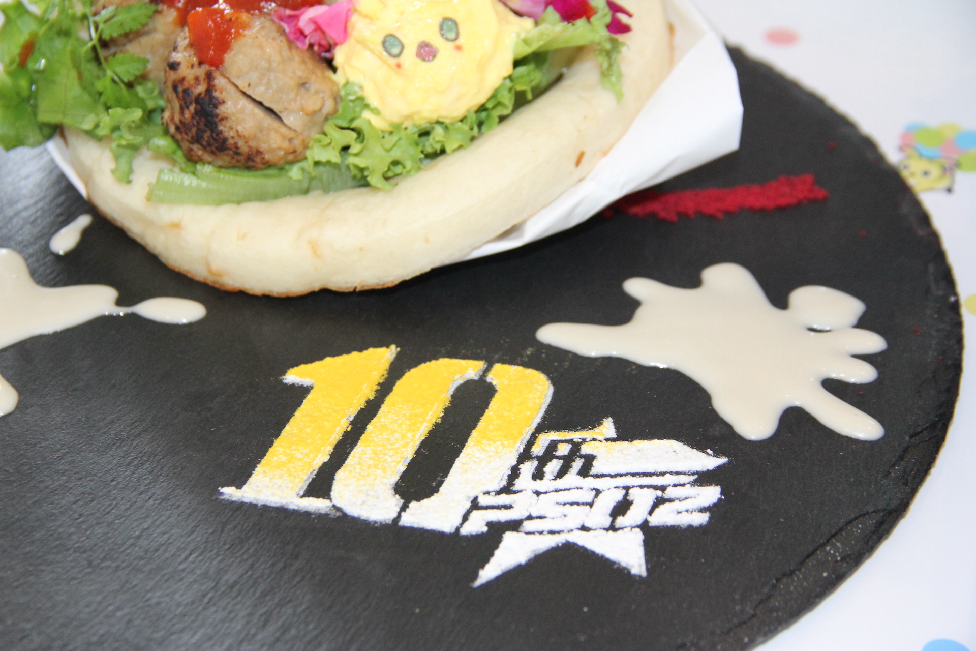 10周年のロゴが目に鮮やかに飛び込んでくる。カラフルな食材に囲まれたラッピーと共に10周年を祝おう