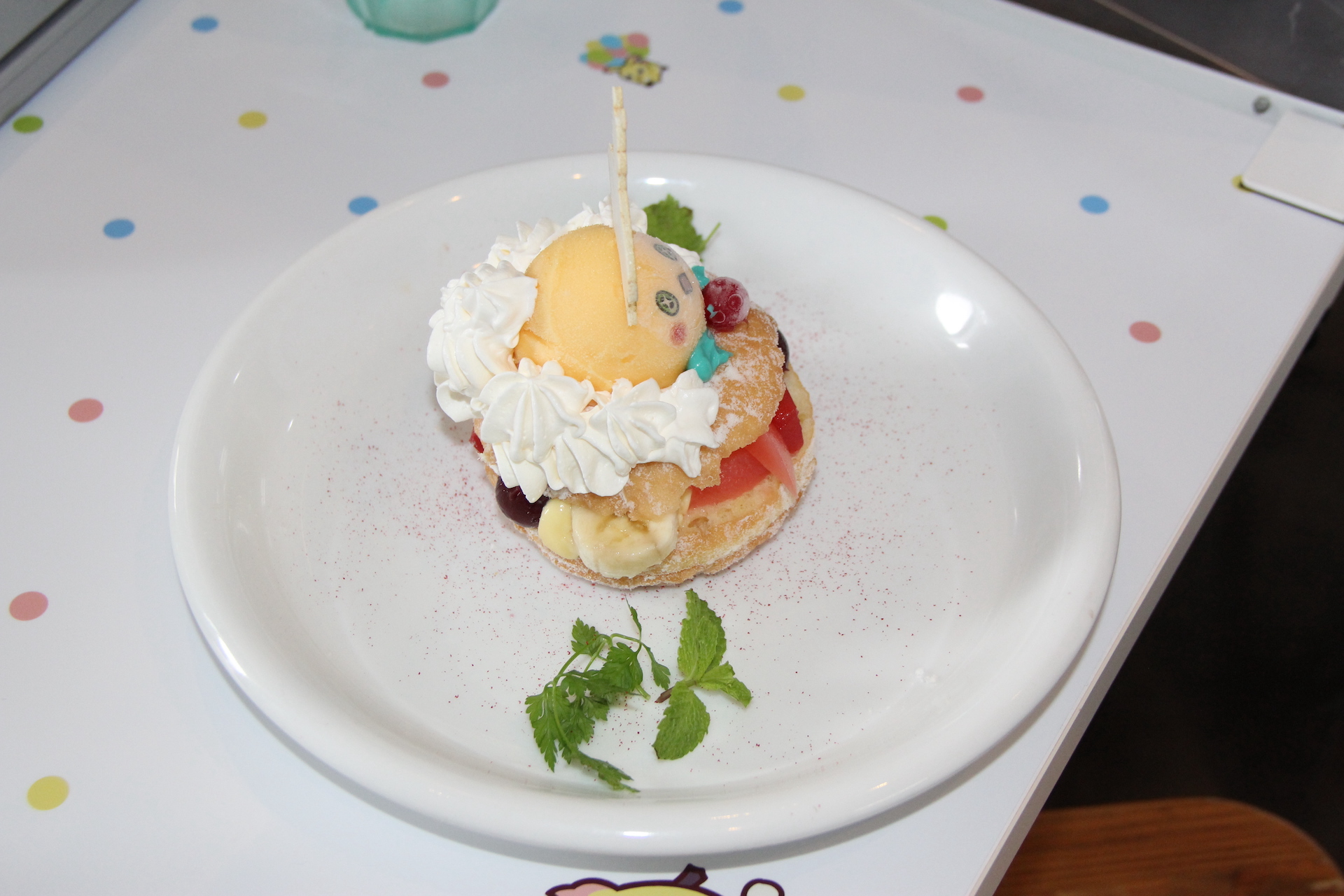 10周年記念に登場したセレモ・エンペラッピーをイメージした、さまざまなフルーツがサンドされたドーナツ。ちょっと小ぶりなハンバーガー程度の大きさがあるので、入っているフルーツを味わいながら、じっくりのんびり食べたい。前からかぶりつくと後ろのカスタードが落ちてしまうので、おしとやかに食べよう(笑)