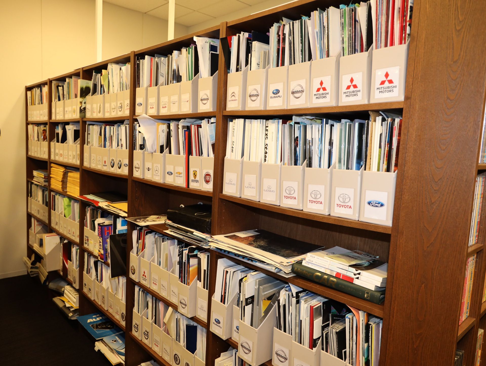 クルマメーカーの歴代のカタログ。25年分がつまっている