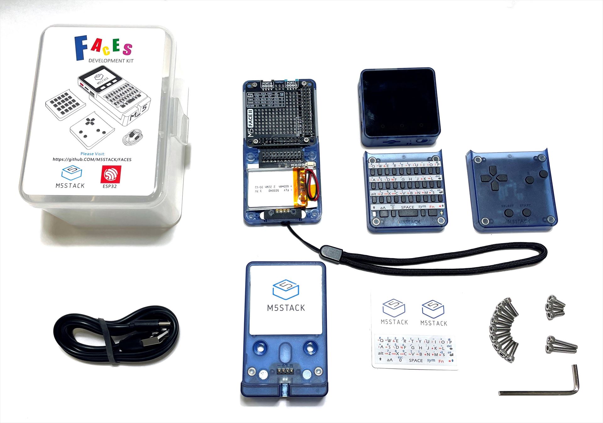 MSX0の量産試作機と周辺パーツ。これが基本セットとしてクラウドファンディングで頒布される。さらにおまけとしてTシャツやシール、ストラップなどが付属する予定だ。左上から時計回りに、基本セットが収納できるケース、M5FacesIIボトムベース、M5Stack Core2、QWERTYキーボード、ゲームパッド、固定用ビス、シール、充電ベース、USBケーブルである