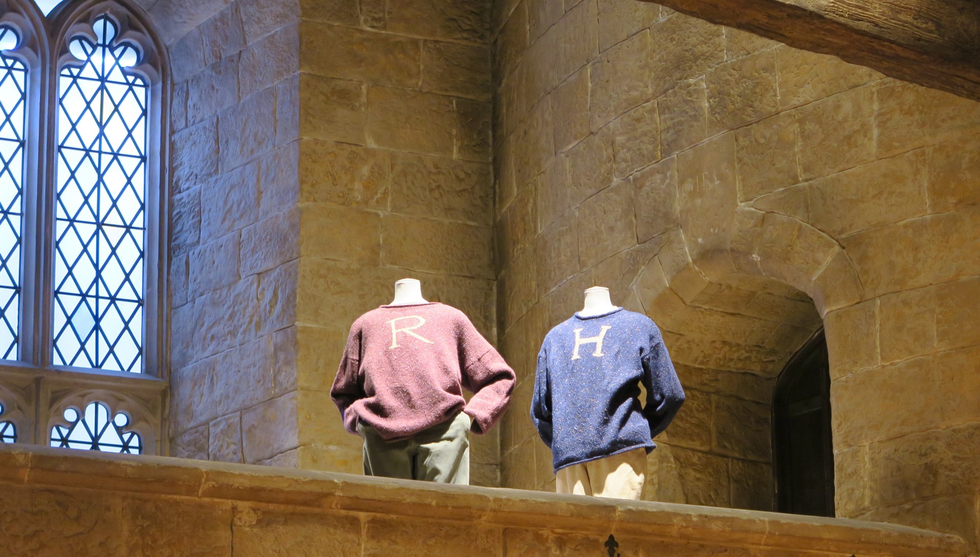 「R」のロンのセーターと「H」のハリーのセーターの背後に位置する女子寝室への入り口には、うっすらと「GIRLS」の文字がみえる